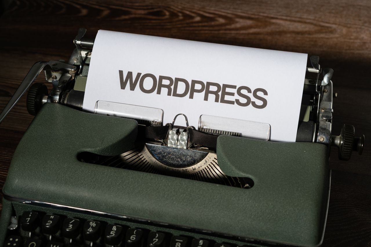 Close-up of a vintage typewriter with WordPress typed on white paper.